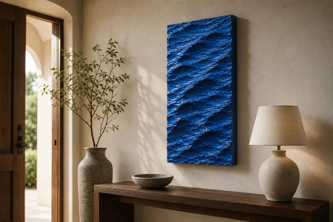 Blue handmade wave wall art in a refined entryway above a wood console